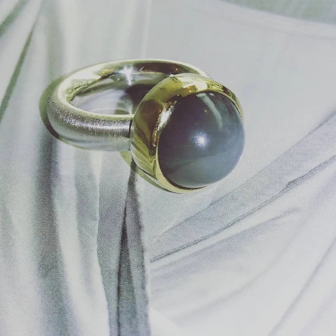 Ring mit violett schimmerndem Stein auf Stoff